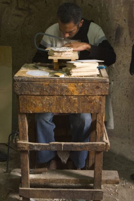 An artist works at his craft funded through Microfinance