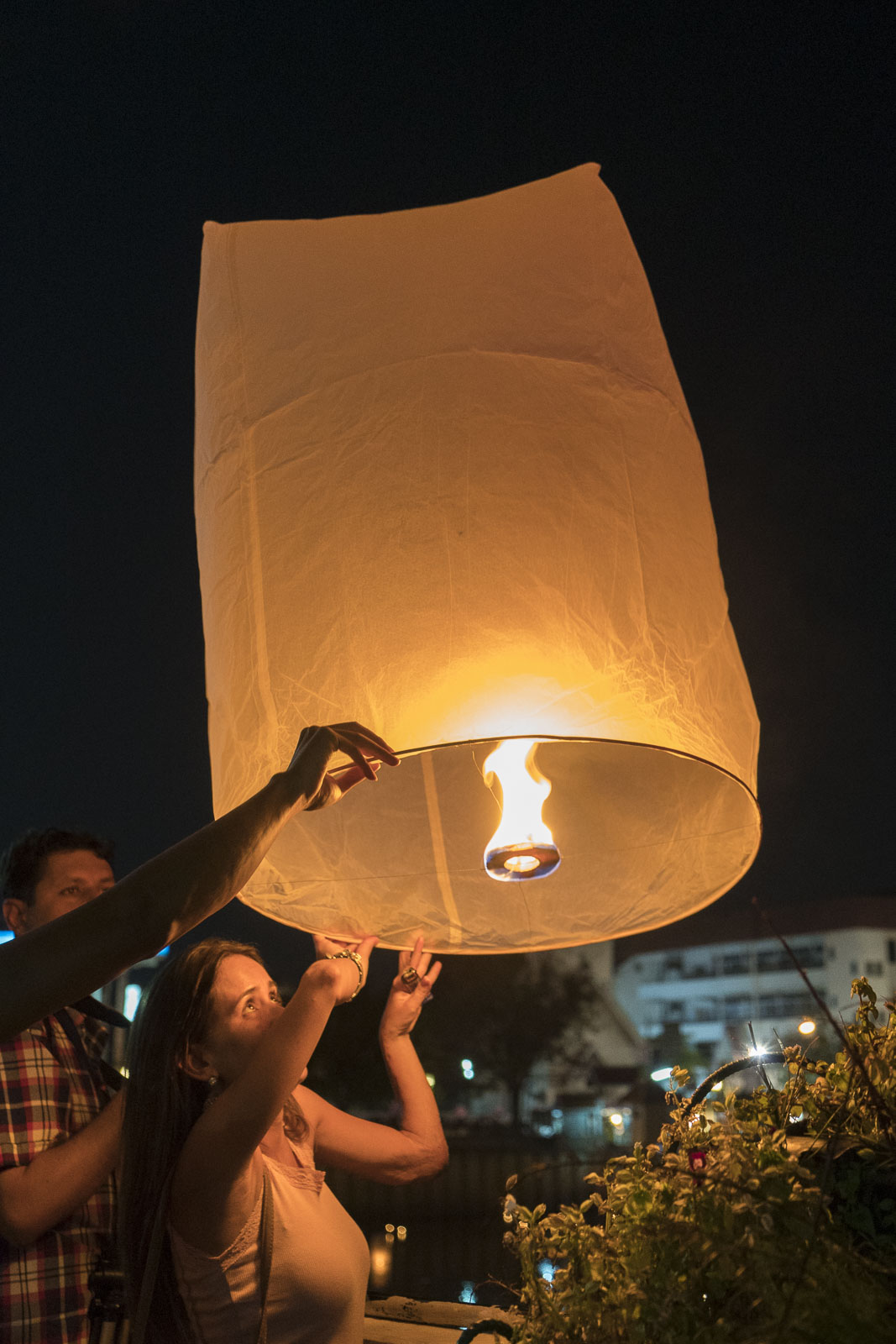 Lighting lanterns at the Yi Peng Festival in Chiang Mai Thailand
