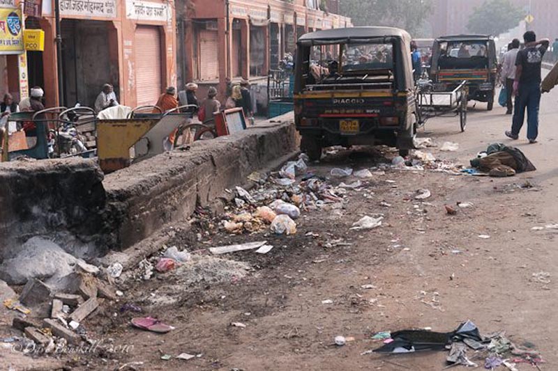 filthy india streets with tuk tuk