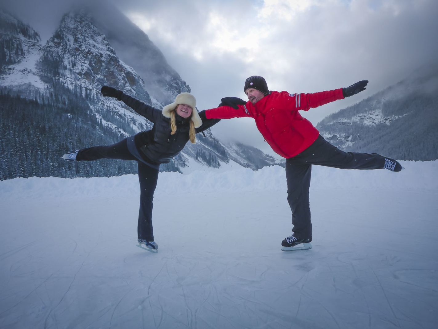 couples traveling skating in lake louise