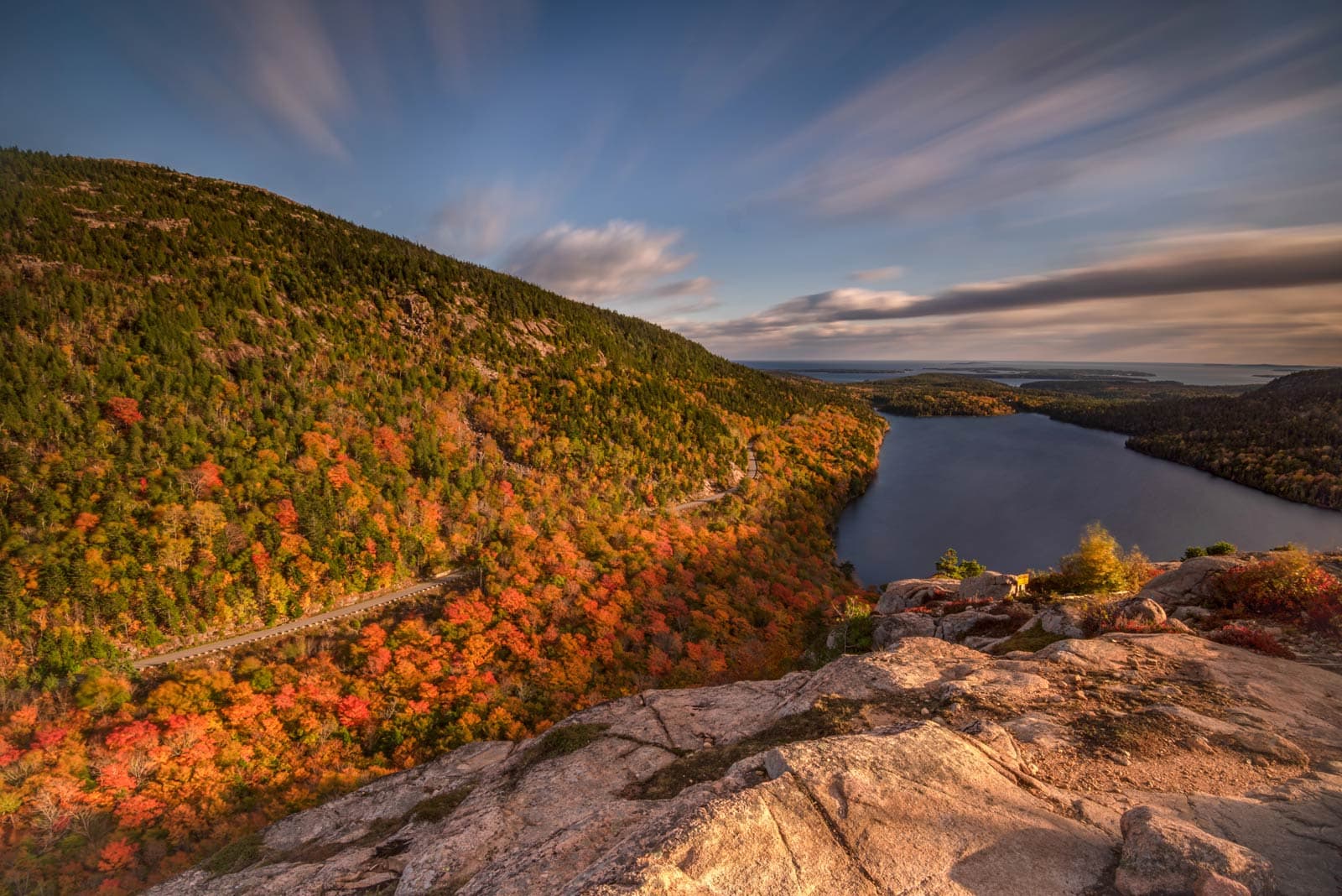 View from Cadillac Mountain overlooking colorful fall trees and the ocean in Acadia National Park