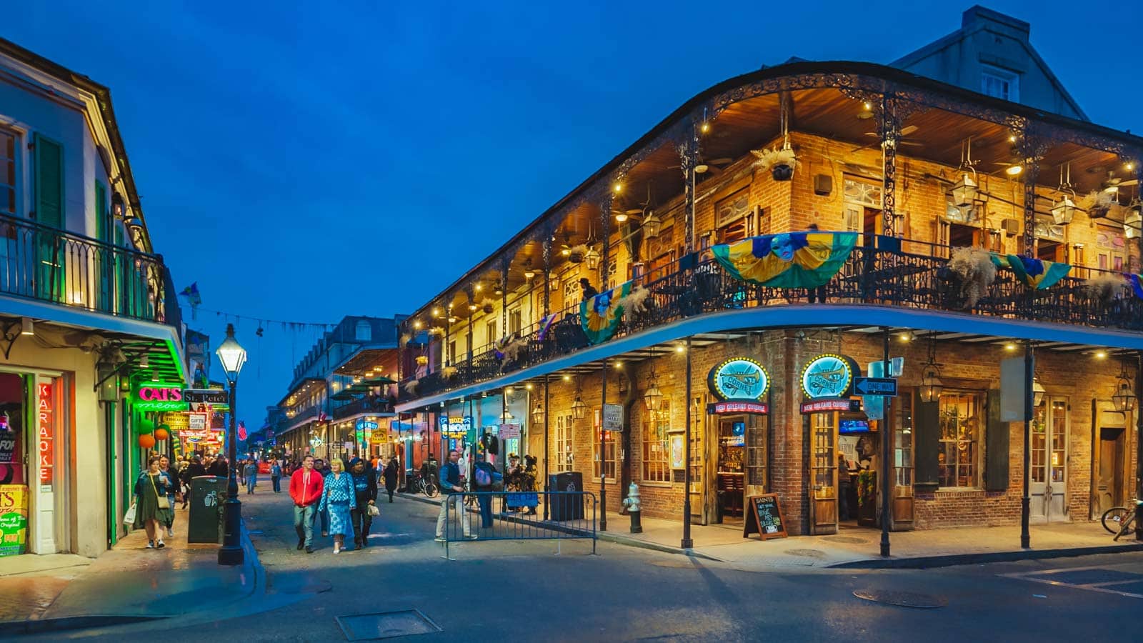 21 Best Places to Visit in December in the USA (2025 Edition) A historic wrought-iron balcony in the French Quarter of New Orleans, decorated with festive Christmas garlands.