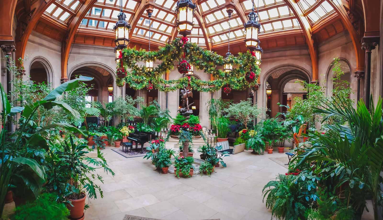 21 Best Places to Visit in December in the USA (2025 Edition) The grand banquet hall at the Biltmore Estate in Asheville, decorated with a giant Christmas tree.