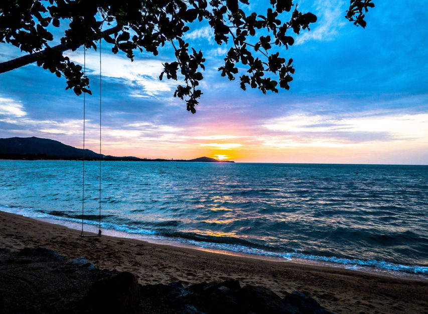 swing on thailand beach at sunset