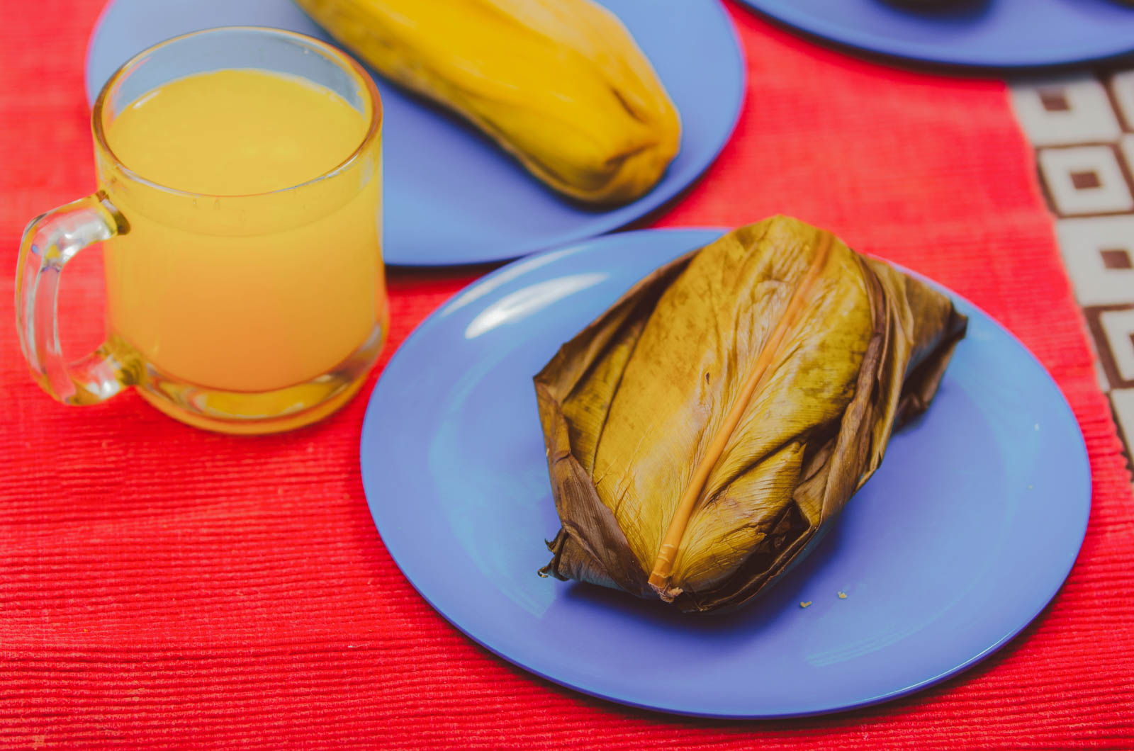 A Cuban tamal unwrapped from its corn husk, showing the moist corn masa mixed with seasoned pork.