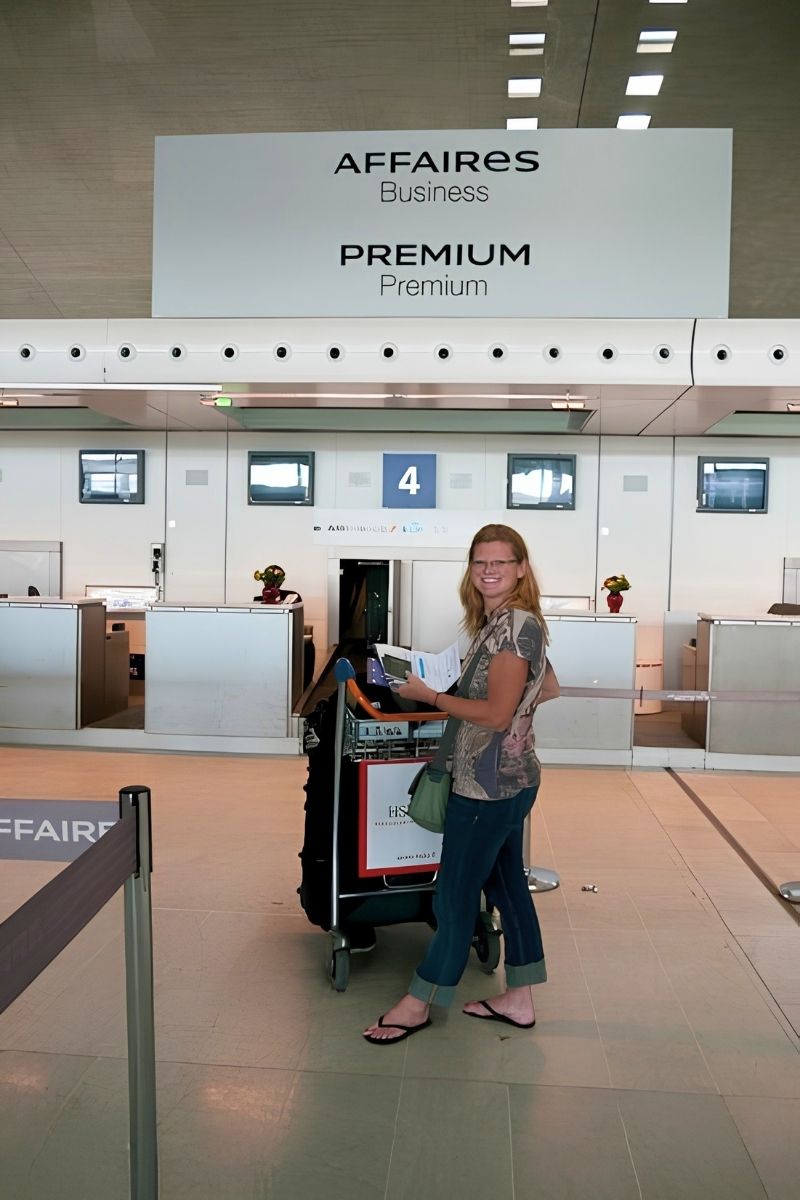 Traveler checking luggage at an airport counter where passengers should photograph the baggage tag before the suitcase goes behind the scenes.