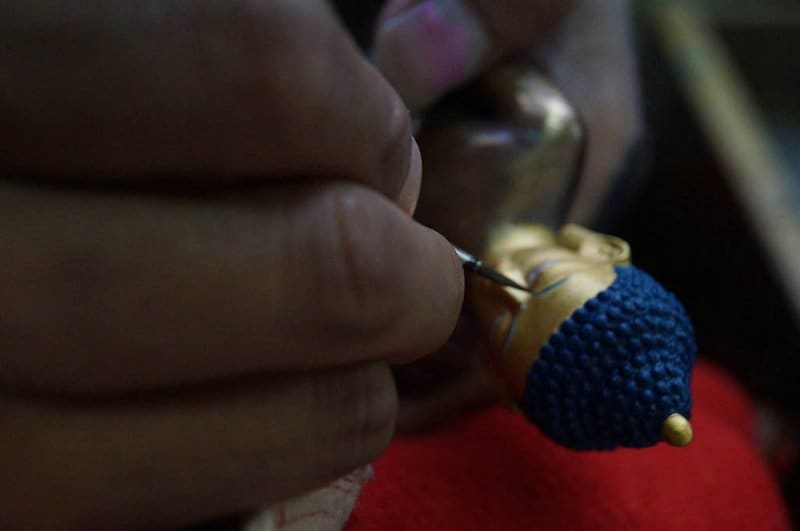 solo female travel India - himachel pradesh - man painting Buddha in Dharamshala