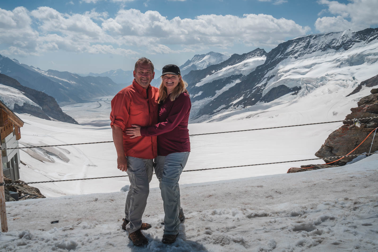 Dave and Deb at Jungfraujoch with snowy alpine peaks and glacier view