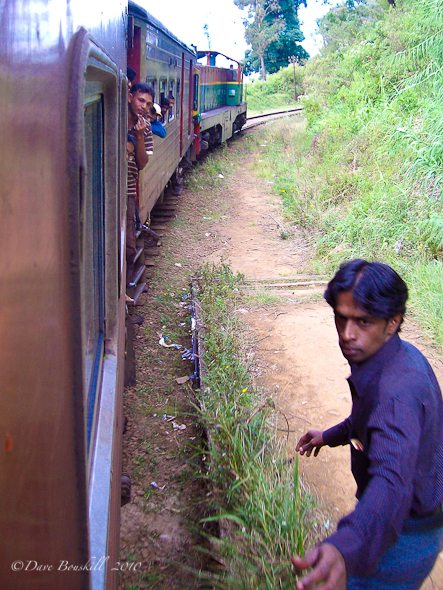 man catches a moving train in Sri Lanka