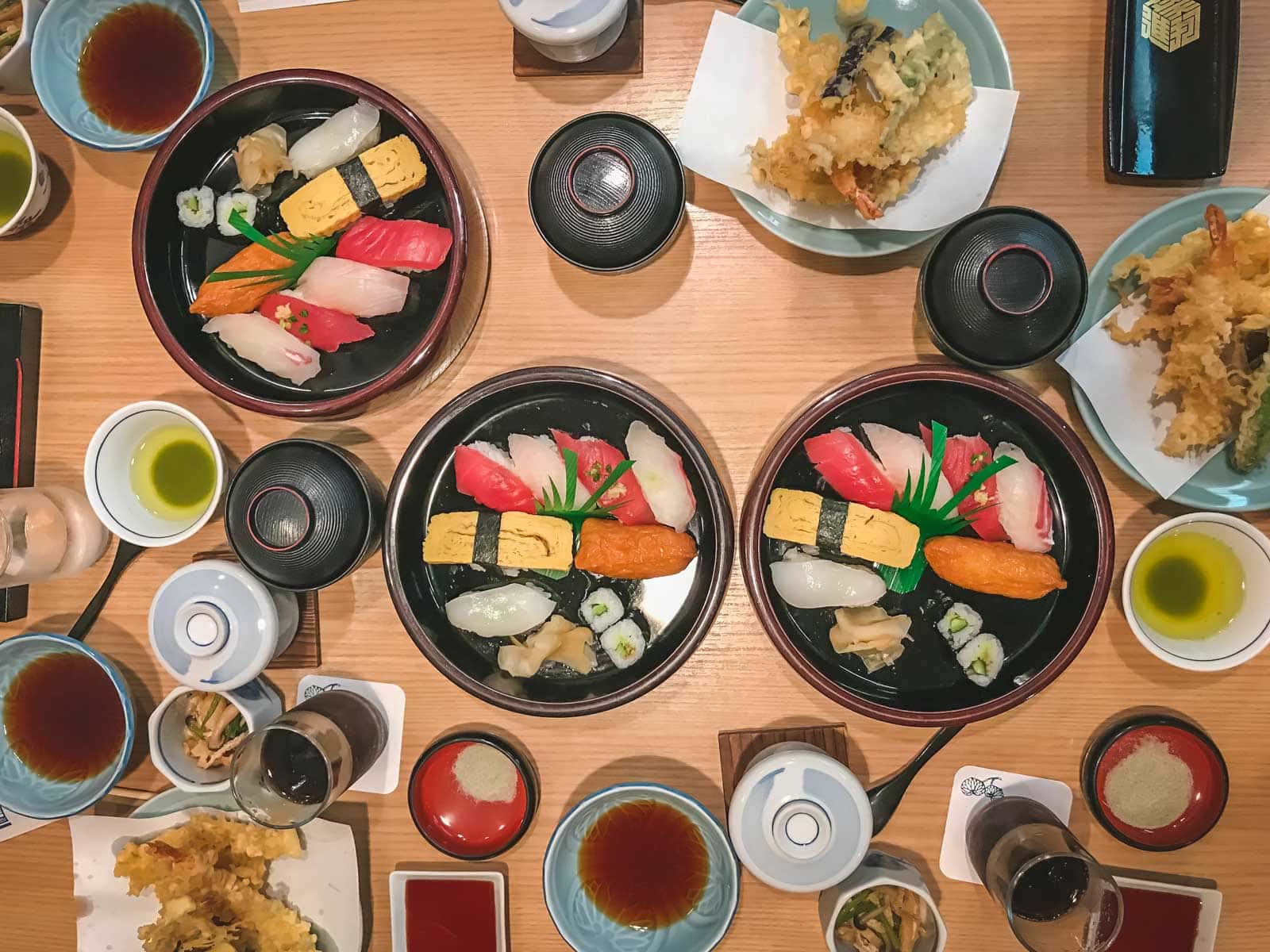 A beautifully arranged platter of colourful and fresh sushi and sashimi, ready to be eaten.