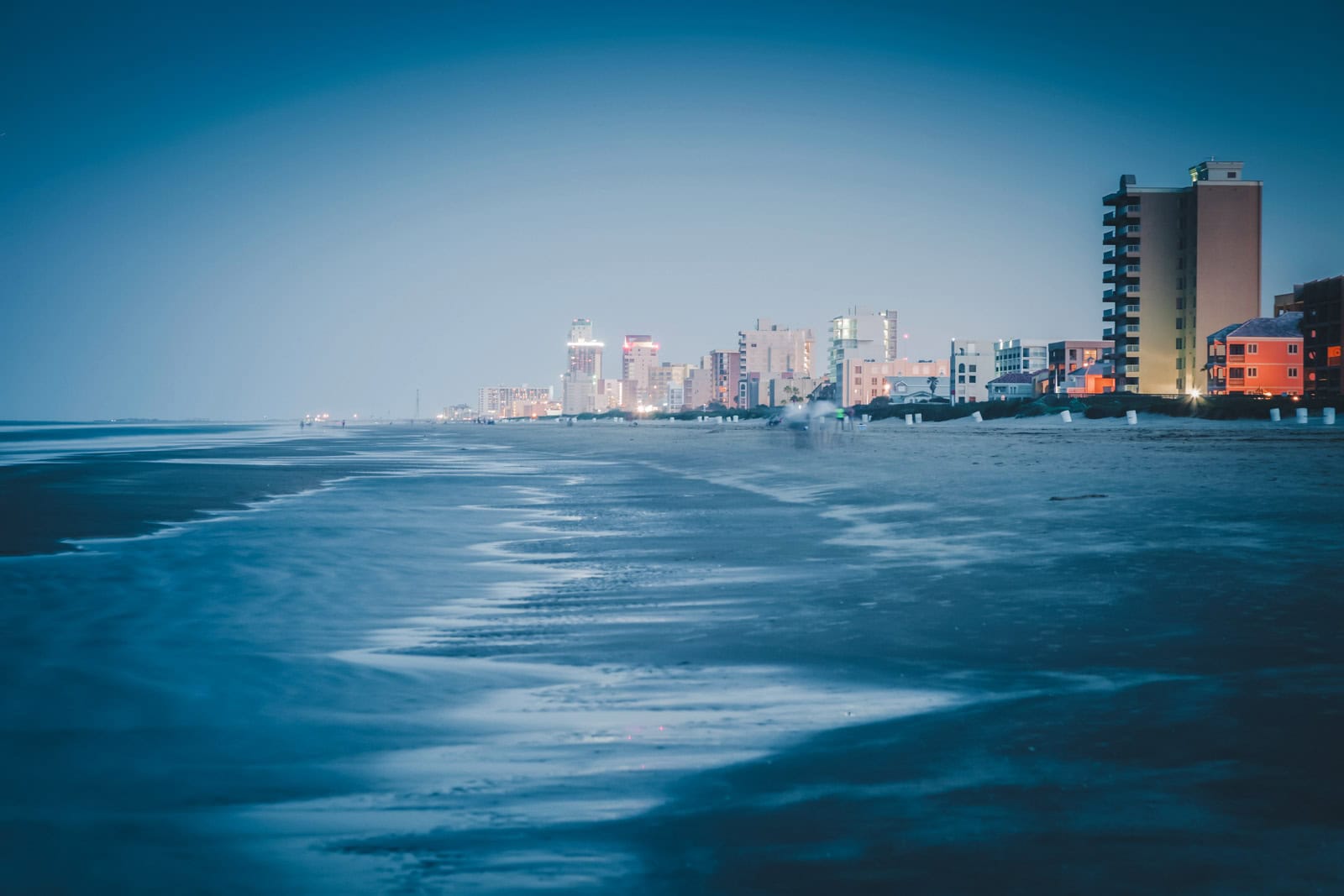 21 Best Places to Visit in December in the USA (2025 Edition) A wide, quiet beach with sand dunes on South Padre Island, a warm place to visit in December in the USA.